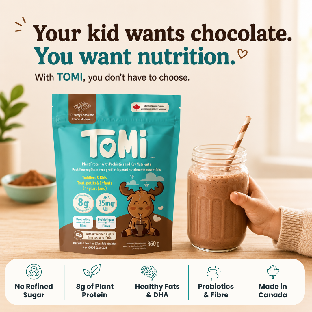 Tomi chocolate powder package with a glass of chocolate milk on a wooden surface.