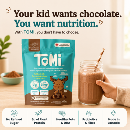 Tomi chocolate powder package with a glass of chocolate milk on a wooden surface.